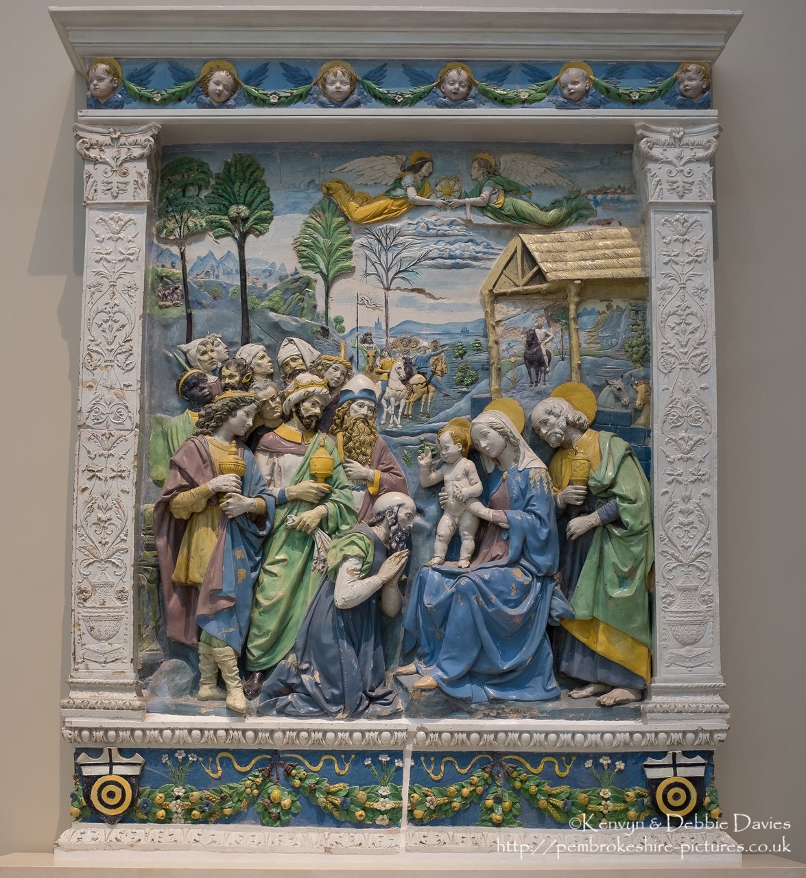 The arms of the lower panel show that the wealthy Albizzi family commissioned this altarpiece. The exotic headgear worn by the king's followers (including the African man) signifies that they were from the East. The bright colours of the altarpiece demonstrate the skill of the della Robbia in producing the tin-glazed terracotta.??Victoria and Albert Museum, London.