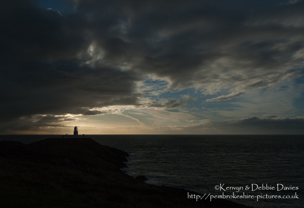 Strumble Head Lighthouse is built on Ynysmeicl (St. Michael's Island), an islet to the west of Fishguard, separated from the mainland by a very narrow gap.<br/><br/>The station was built in 1908 by Trinity House for the greater safety of sea traffic between Ireland and Fishguard Harbour which is located behind cliffs and a breakwater three miles to the east. The new light also formed a link with the existing South Bishop light, 18 miles to the south-west. This stretch of coast is very dangerous, and some 60 vessels are known to have been lost along it in the 19th Century alone.