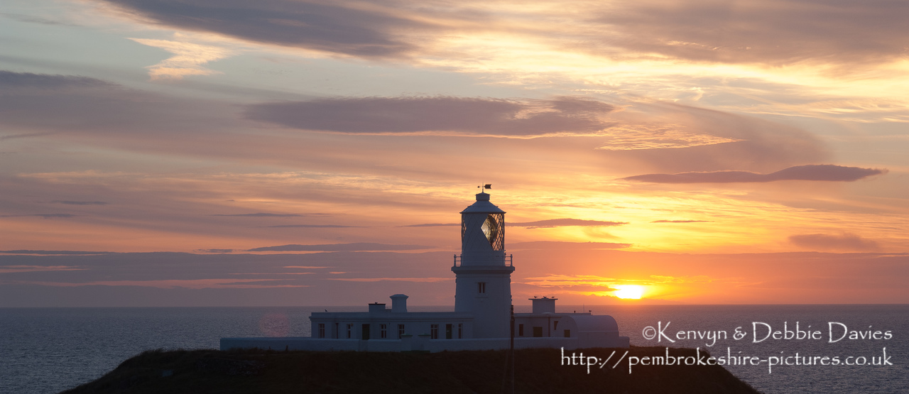 Strumble Head Lighthouse is built on Ynysmeicl (St. Michael's Island), an islet to the west of Fishguard, separated from the mainland by a very narrow gap.<br/><br/>The station was built in 1908 by Trinity House for the greater safety of sea traffic between Ireland and Fishguard Harbour which is located behind cliffs and a breakwater three miles to the east. The new light also formed a link with the existing South Bishop light, 18 miles to the south-west. This stretch of coast is very dangerous, and some 60 vessels are known to have been lost along it in the 19th Century alone.
