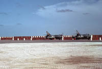 Hawker Hunter FR10s of 1417 Flight at RAF Khormaksar circa 1966   Protected by stacked 40 gallon drums of "fresh" water.